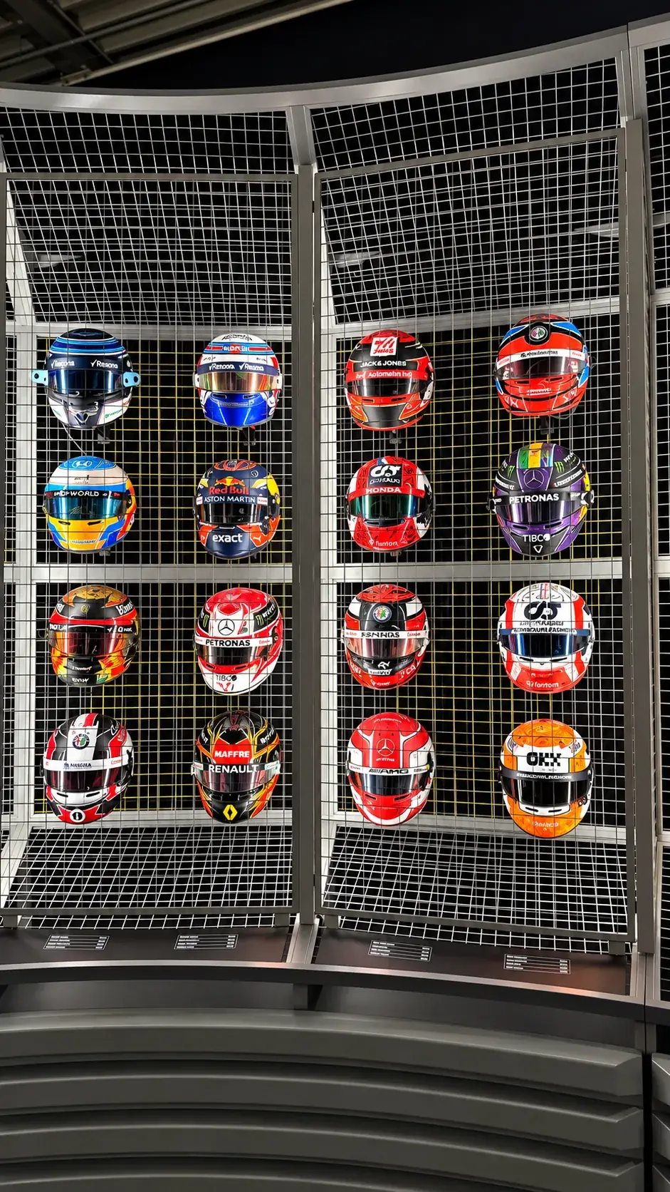 Wall of Formula 1 helmets mounted in a mesh display frame