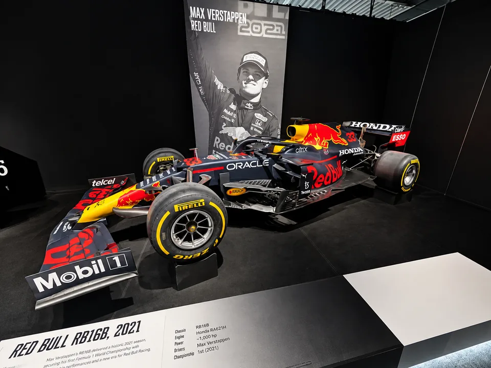 Red Bull RB16B on display with a Max Verstappen banner behind it