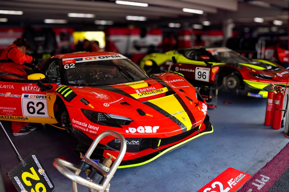 Number 62 and number 96 Ferrari 296 GT3 cars inside a team garage
