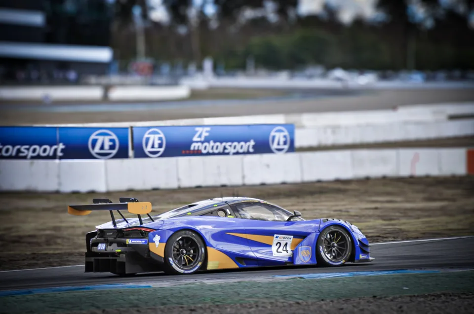 Blue and gold number 24 McLaren 720S GT3 seen from behind on track